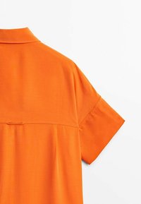 Short-sleeved, button-up shirt in bright orange fabric, featuring a simple collar, back yoke, and smooth texture.