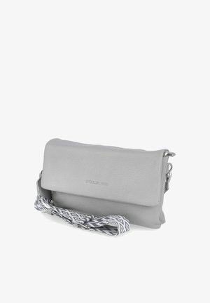 Kleine graue Leder-Umhängetasche mit Klappe und abnehmbarem schwarz-weiß gemustertem Gurt daneben liegend.