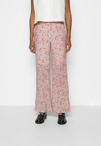 Calças largas com estampado floral, apresentando flores vermelhas e roxas sobre um fundo claro; feitas de tecido leve com cintura elástica.