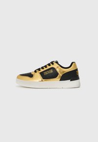 Sorte og gyldne sneakers med en skinnende metallisk finish, tekstureret overdel, perforerede detaljer, snørebåndslukning og hvid gummisål.