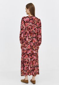 Long, black dress with a pink and orange paisley print, long sleeves, and a cinched waist. Soft fabric with a flowing design.