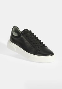 Schwarze Ledersneaker mit strukturiertem Obermaterial, Schnürdesign und kontrastierender weißer Gummisohle. Runde Zehenpartie und gepolsterter Kragen für Komfort.