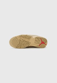 Apavu zole ar krēmveida gumijas materiālu, kurai ir tekstūras raksti, apļveida saķeres un sarkana Jumpman logo akcenta daļa uz papēža.