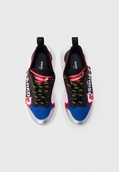 Πολύχρωμα αθλητικά παπούτσια με κόκκινο, μπλε, μαύρο και λευκό δίχτυ, διακοσμημένα με ασημένιες λεπτομέρειες. Περιλαμβάνουν μαύρα κορδόνια και χαρακτηριστική καρτέλα με λογότυπο.