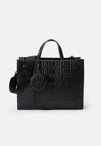 Sort læder tote taske med præget "STEVE MADDEN" logo, dobbelte top-håndtag, aftagelig rem, og en rund pung fastgjort med hardware.
