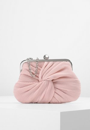 Blød lyserød clutch taske med plisseret stof med snoet design, sølvmetalramme og kort sølvkædehåndtag på en hvid overflade.