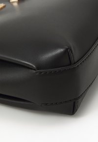 Black leather bag with a smooth texture, featuring stitched edges and a flat rectangular shape. No visible hardware or accents.