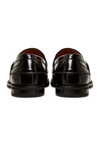 Black patent leather loafers with a smooth finish, rounded toe, and contrasting stitching detail. Low heel with rubber outsole.
