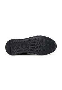 Suola di scarpa in gomma nera con una texture a punti irregolari e scanalature orizzontali, progettata per la trazione. Logo circolare al centro.
