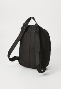 Zaino in tessuto nero con spallacci regolabili, forma arrotondata e superficie testurizzata. Caratterizzato da accessori in plastica e un design minimalista.