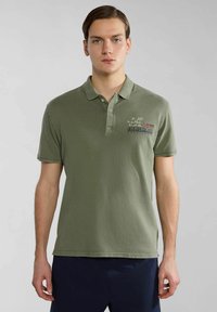 Polo shirt verde oliva in cotone, con colletto, maniche corte e logo e testo ricamati sul petto.
