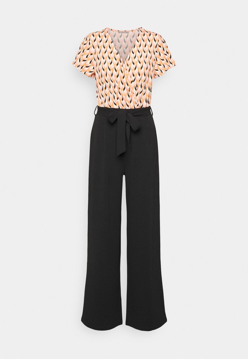 Haut cache-cœur à manches courtes avec motif géométrique pêche, noir et blanc, associé à un pantalon noir à taille haute et jambes larges avec ceinture nouée.