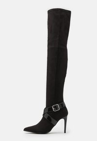 Botas negras hasta la rodilla hechas de suave ante, con punta afilada y una correa de charol brillante con un detalle de hebilla.