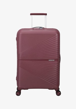 Valigia rigida bordeaux con texture a coste diagonali, quattro ruote girevoli e manico telescopico estensibile.