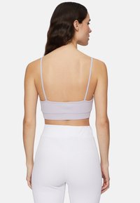 Ljuslila ribbad bralette med tunna band, med en kort design och bandad nederkant, tillsammans med vita ribbade byxor med hög midja.