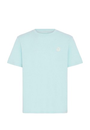 Hele sinine T-särk, valmistatud pehmest, tekstuurse kangaga. Sellel on ümmargune kaelus ja väike tikitud logo vasaku ülemise rinna kohal.