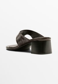 Brown leather heeled sandals with a rounded design, open toe, and a wide, block heel. Smooth texture with a slight sheen.