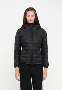 Black puffer jacket with a hood, featuring a quilted design, front zipper, and slim fit. The material appears smooth and lightweight.