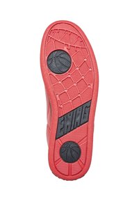 Semelle de chaussure de sport en caoutchouc rouge avec un motif géométrique de traction et un logo de basket-ball circulaire noir. Surface texturée pour une meilleure adhérence. Marque Ewing visible.