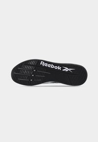 Σόλα μαύρου παπουτσιού Reebok με λευκό λογότυπο, με αυλακώσεις και υφασμένα σχέδια λαβής σε απλό φόντο.