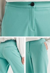 Ljust teal-färgade byxor med en slätt textur, med knappstängning, sidofickor och standardpassform. Baksidan har en passpoalerad ficka.