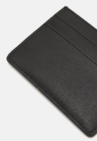 Portafoglio nero realizzato in pelle testurizzata con tre scomparti per carte. Presenta una finitura liscia e cuciture precise lungo i bordi.