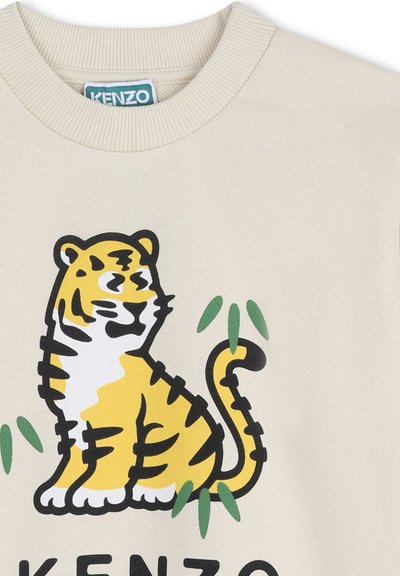 Felpa beige chiaro con grafica di una tigre nera e gialla, con dettagli in bambù verde. Girocollo a coste e texture morbida.