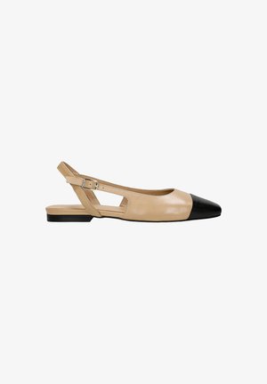 Flats en cuir beige à talon bas, avec un embout noir, des découpes rectangulaires sur les côtés et une bride ajustable à la cheville.