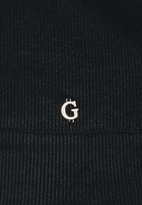 Černá žebrovaná tkanina se malým stříbrným akcentem "G" připevněným uprostřed. Textura vypadá měkce s vertikálními liniemi.