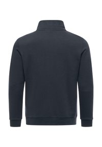 Pullover navy con una texture morbida, dotato di un colletto alto e dettaglio ricamato "wear" sul collo. Maniche lunghe e polsini a coste.