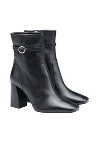 Stivali ankle in pelle nera con tacco a blocco, punta affusolata, chiusura con zip e una fascia decorativa con dettaglio a cerchio in argento.