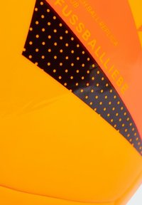 Palla da calcio gialla e arancione con accenti neri, caratterizzata da motivi a pois e testo stampato "Fussballliebe" per il branding.