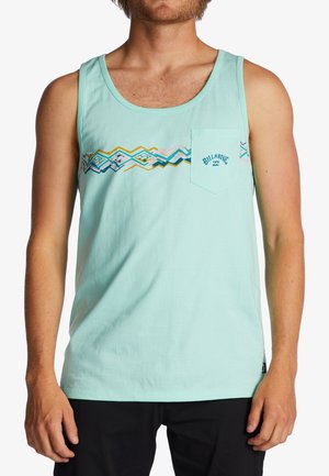 Mann trägt hellblaues ärmelloses Tanktop mit geometrischem Muster und Billabong-Logo auf der Brusttasche, kombiniert mit schwarzen Shorts.