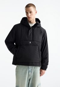 Giacca nera a pullover con cappuccio, dotata di una tasca frontale e polsini elastici. Realizzata in tessuto liscio e imbottito, con un design slim fit.