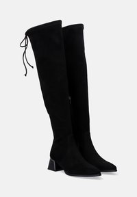 Botas negras por encima de la rodilla hechas de suave ante con un diseño elegante, que cuentan con una punta afilada y un tacón cuadrado. Cinta ajustable en la parte superior.