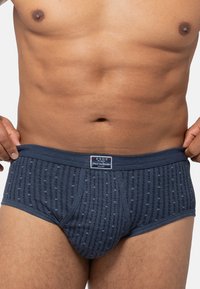 Marineblaue Herrenunterwäsche aus strukturiertem Stoff mit einem gemusterten Design und einem elastischen Bund, der ein Markenetikett trägt.