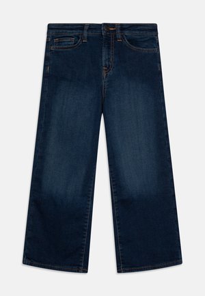 Jean large bleu foncé avec une texture lisse, comportant deux poches avant, une fermeture à bouton et des coutures orange contrastantes.