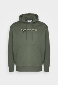 Felpa color verde oliva in misto cotone, con tasca a marsupio frontale, cappuccio con cordino e logo Calvin Klein in colori a contrasto.