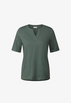 Krátký rukáv, olivově zelené tričko s výstřihem do V, vyrobené z měkké strukturované tkaniny, s ohrnutými manžetami a rovnými lemy. Viditelná značka CECIL.