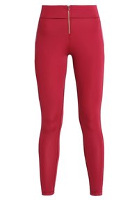 Leggings sportivi rossi con vita alta, texture liscia, tasca frontale con zip e pannelli laterali in rete per traspirabilità.