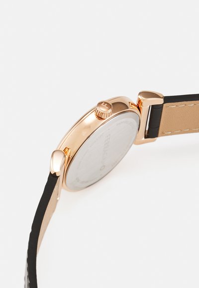 Ohišje zapestne ure iz rožnatega zlata s črnim in rjavim usnjenim paščkom, prikazuje stran in zadnji del ure z natančno oblikovano krono in nosilci.