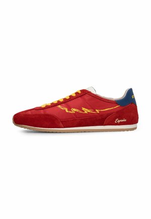 Czerwony sneaker z żółtym wzorem błyskawicy, żółtymi sznurowadłami, niebieską pętelką na pięcie, białą podeszwą i nadrukiem "Espania" na boku.