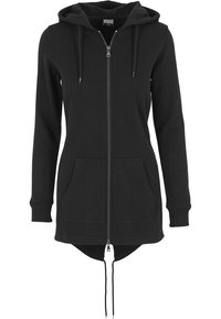 Sudadera con capucha negra de manga larga con cremallera, bolsillos frontales, cordones y una capucha, con un dobladillo trasero ligeramente más largo.