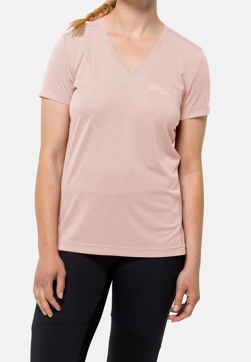 Ljusrosa, kortärmad V-ringad t-shirt i mjukt tyg, med en diskret logotyp på vänster bröst och en avslappnad passform. Svarta leggings.