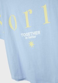 Tissu bleu clair avec de grandes lettres jaune pâle et un texte blanc "TOGETHER is better" au-dessus d'une étoile jaune à huit branches.