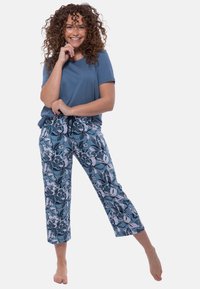 Lichtblauw T-shirt met korte mouwen, gecombineerd met cropped broek met een bloemenpatroon in tinten blauw en wit, elastische tailleband en trekkoord.