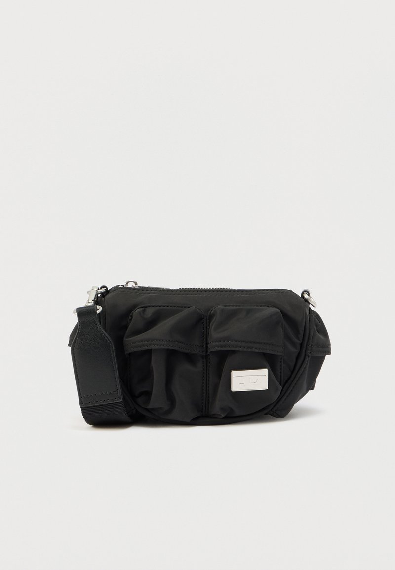 Svart nylon skulderveske med to lommer foran, sølvglidelås og en avtakbar stropp. Har en liten logodetalj på siden.