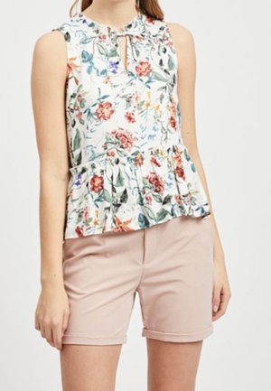 Blusa blanca sin mangas con estampado floral multicolor y dobladillo con volantes combinada con pantalones cortos confeccionados en rosa claro.