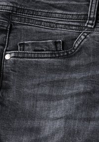 Tumman denim-kankaan farkut, joissa on tyylikäs pinta, pienen etutaskun ja metallinappikoristeen kanssa. Näkyvät saumat lisäävät yksityiskohtia.