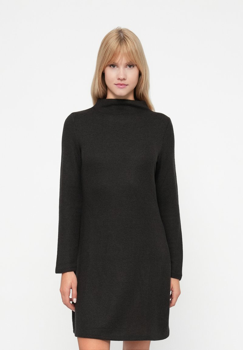 Μαύρο, φόρεμα σε στυλ πουλόβερ με ψηλή λαιμόκοψη, μακριά μανίκια και ριγωτή υφή. Φτάνει πάνω από τα γόνατα με πλαϊνές σχισμές.